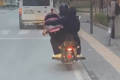 Motosiklet üzerinde bebeği pusetiyle taşıdı
